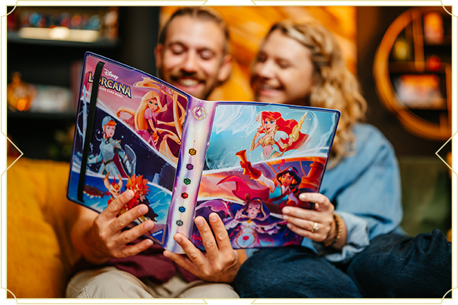 Image of a woman and man smiling as they review Lorcana cards