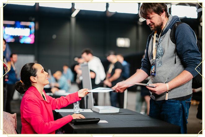 Artist hands a signed Disney Lorcana card to an attendee at Disney Lorcana Challenge Ghent
