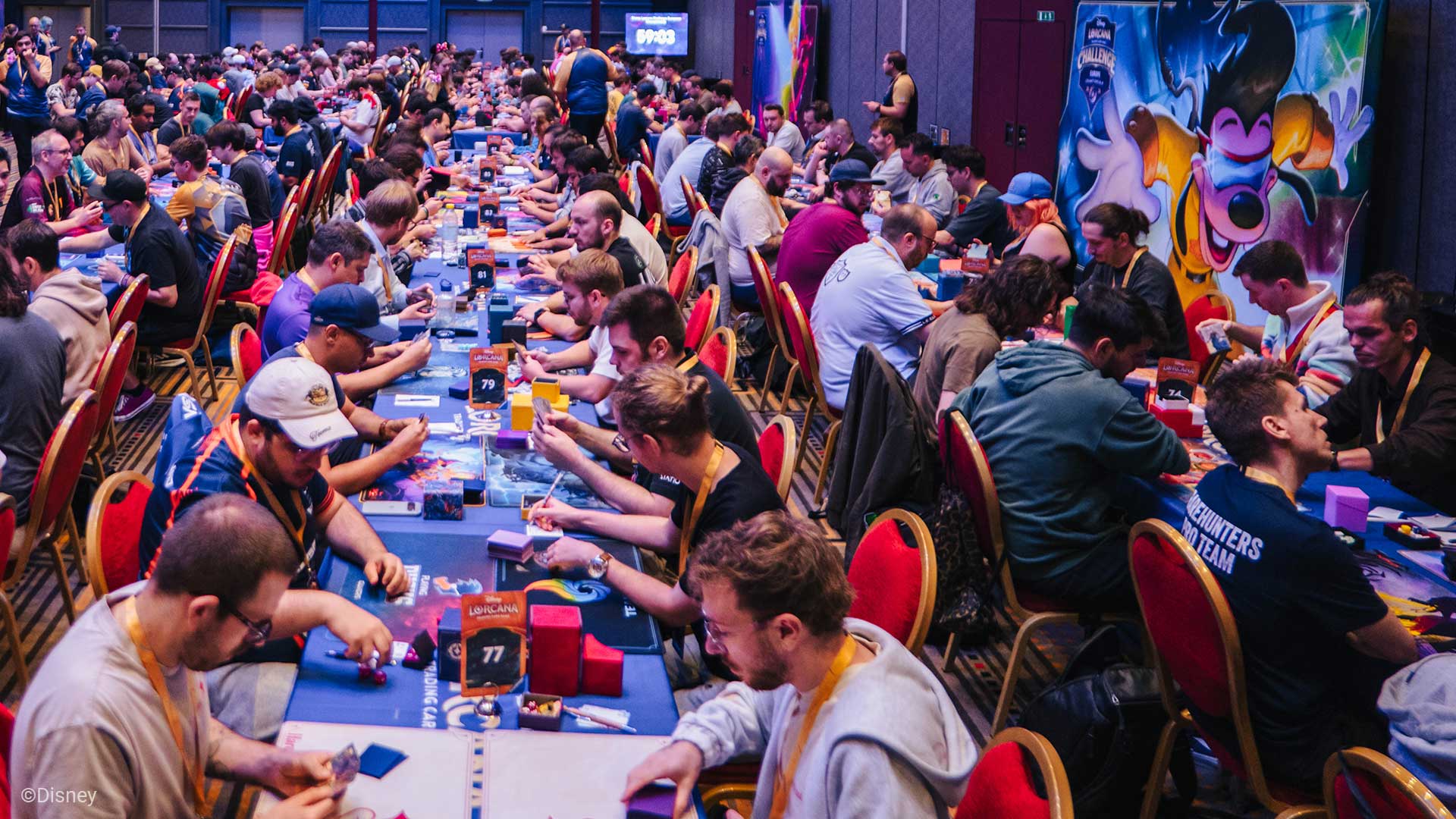 hundreds of Disney Lorcana players seated at many tables